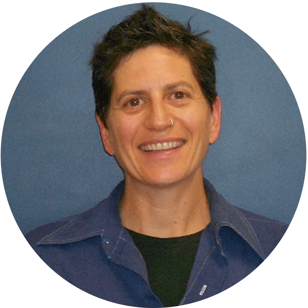 Female with short brown hair wearing a blue button up shirt over a black tshirt